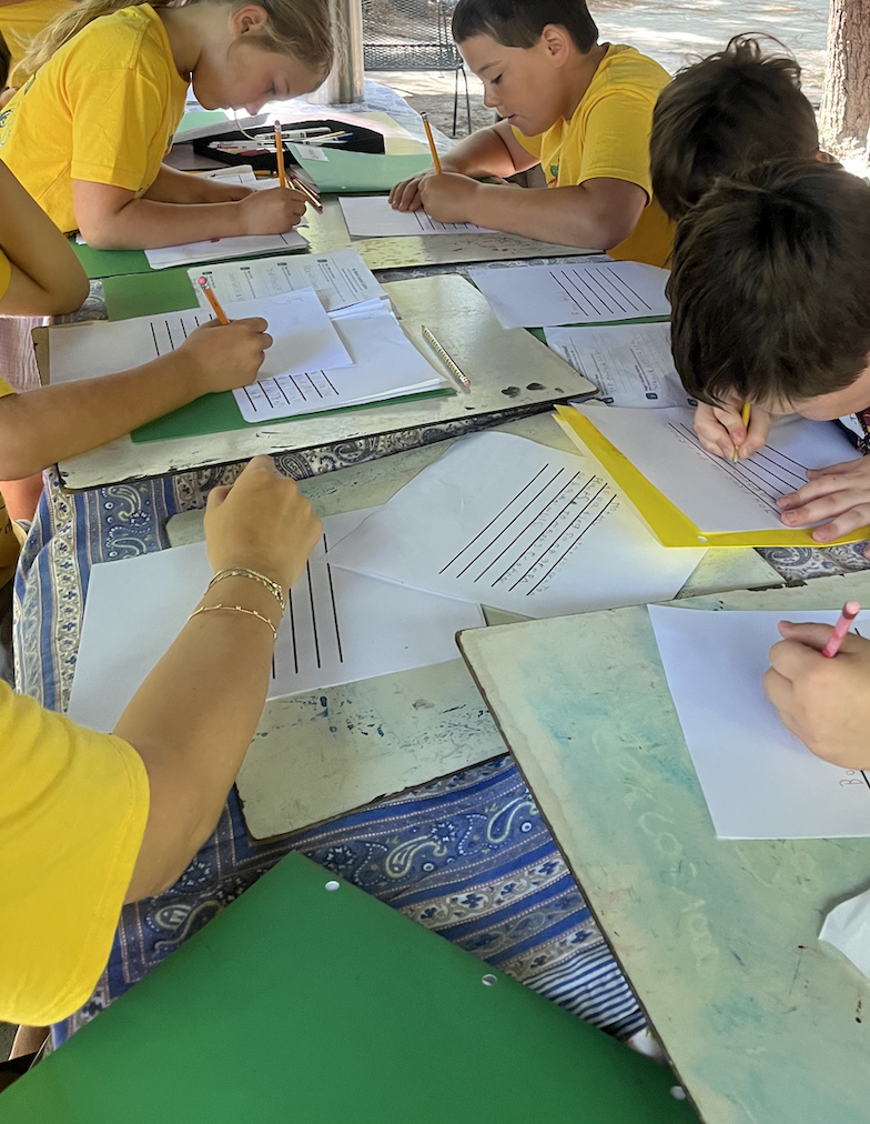 Students writing together at tables