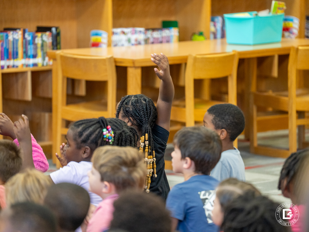 Students raising their hands during classroom discussion